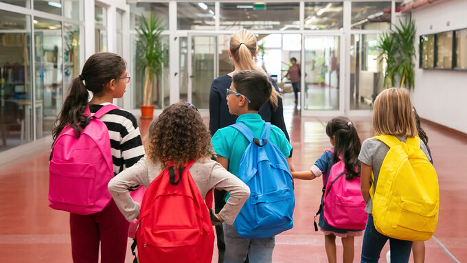 group-children-with-female-teacher-walking-school-corridor.jpg
